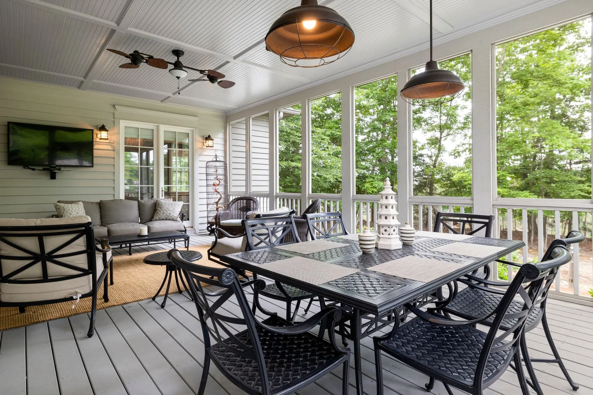 Covered patio with a white lined ceiling, pendant light and outdoor dining setting